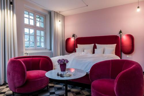 埃森埃森米乔普斯塔特酒店的一间卧室配有一张床、两把椅子和一张桌子