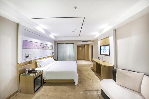 北京麗枫酒店·北京亚运村店的酒店客房,配有床和沙发