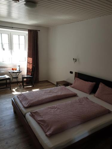 科伯恩-贡多夫Gastehaus in der Alte Kellerei的一间卧室设有两张床、一张桌子和一个窗口