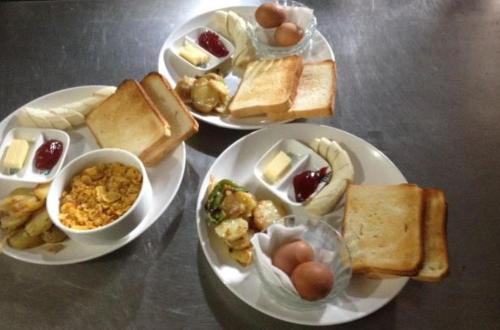 博卡拉HOTEL ICE VIEW POKHARA的一张桌子,上面放着三盘食物,包括鸡蛋和面包