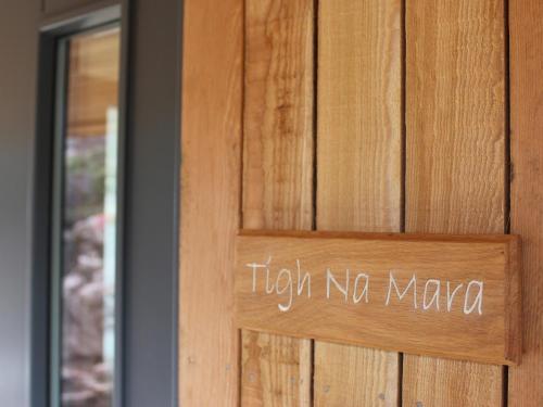 阿勒浦Tigh na Mara的木门上的一个标志,上面写着不动的紧身