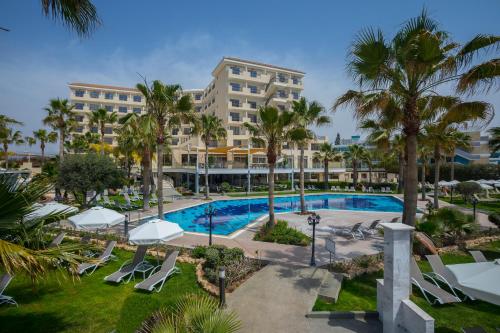 帕福斯爱美尔海滩酒店及度假中心的享有度假村的空中景致,设有游泳池和棕榈树