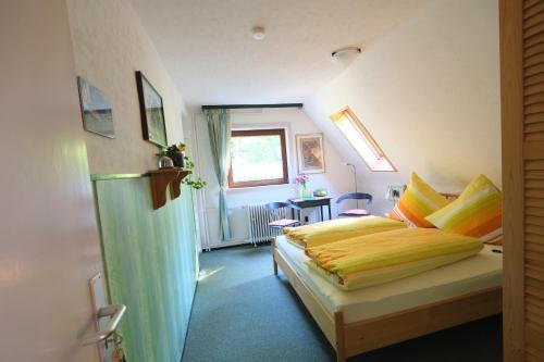 戈斯拉尔阿乐塔旅馆的一间卧室配有一张带黄色床单的床和一扇窗户。