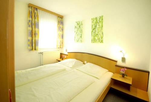 RundingFamilienhotel Reiterhof Runding的一间卧室设有一张大床和一个窗户。