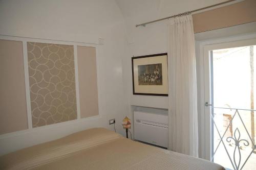 塔尔奎尼亚Camere con vista (Rooms with a view)的一间卧室设有一张床和一个滑动玻璃门