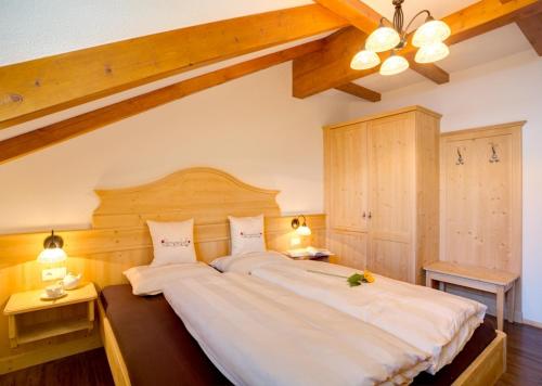圣坎迪朵Parggenhof的一间卧室配有一张带两盏灯的大型白色床。