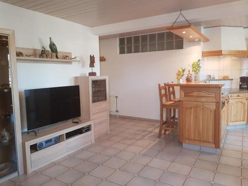 CourcelonApartement-Gîte rural à 3 km de Delémont的厨房配有平面电视和桌子。