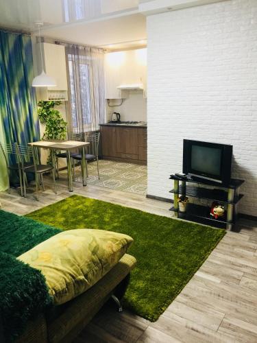 切尔尼戈夫Двухкімнатна студія的带沙发、电视和桌子的客厅