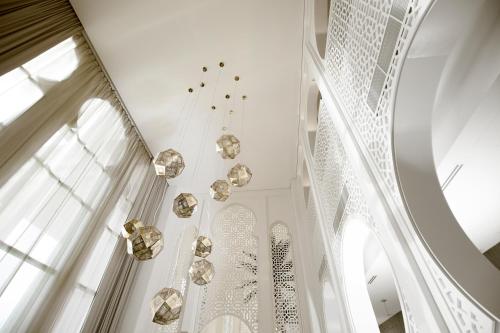 利雅德Shaza Riyadh的白色的客房设有吊灯和窗户。