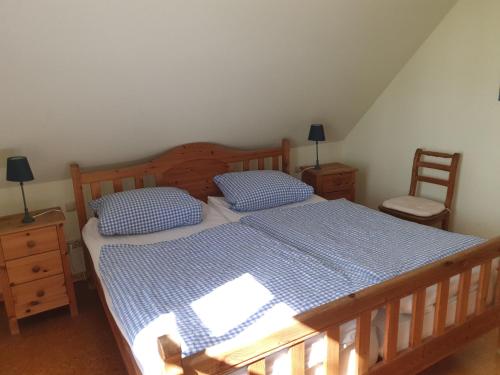 锡克Eschenhof的一间卧室配有一张带蓝色和白色床单的木床。