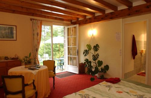 吉维尼Le Clos Fleuri的一间卧室配有一张床、一张桌子和一个窗户。