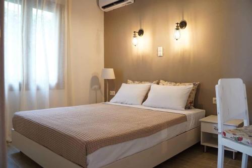 PotamiáInGreen apartment的卧室配有带白色枕头的床和窗户。