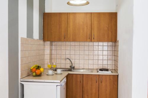 波帝卡Sunset Apartments的一个带木制橱柜和水槽的厨房