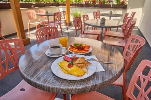 墨西哥城花园墨西哥里夫玛温德姆酒店的餐桌,带两盘食物和一杯咖啡的桌子