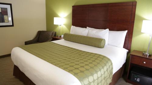 MarquetteCobblestone Inn & Suites - Marquette的酒店客房带一张大床和一把椅子