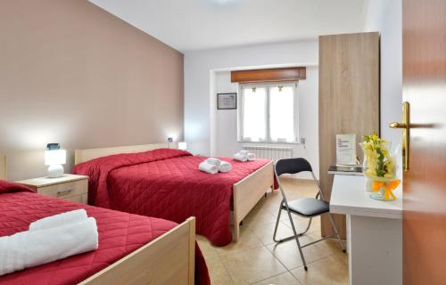 圣焦万尼因菲奥雷Mastro Gio的一间卧室配有两张床、一张桌子和一把椅子