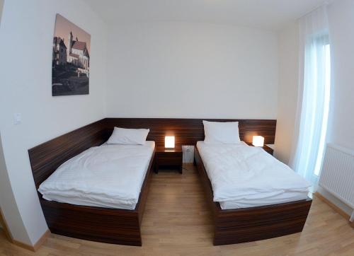 普雷绍夫贝利尔酒店的配有两张床铺的房间,配有两盏灯
