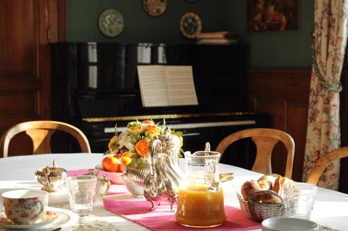 翁弗勒尔拉莉涅尔住宿加早餐旅馆的一张桌子,一张桌子,布和一架钢琴