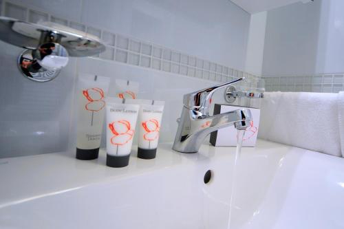 格拉多提齐安诺公寓式酒店的浴室水槽配有水龙头和一些牙刷