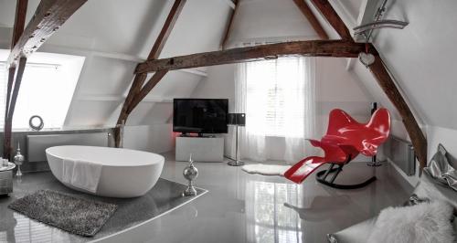 维里天堂套房酒店的一间带大型白色浴缸和红色椅子的浴室