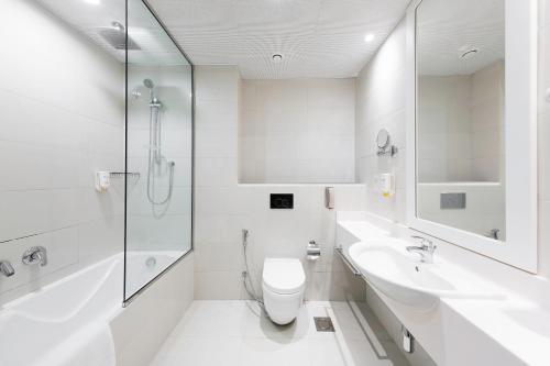 迪拜Citymax Hotel Al Barsha的白色的浴室设有卫生间和水槽。