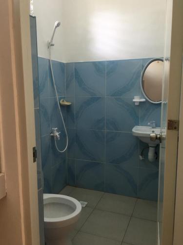 塔比拉兰Panglao Rainbow Inn的蓝色瓷砖浴室设有卫生间和水槽