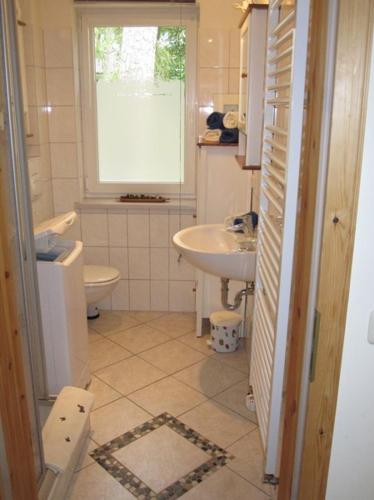 博尔滕哈根Gästehaus am Strand的一间带水槽和卫生间的浴室