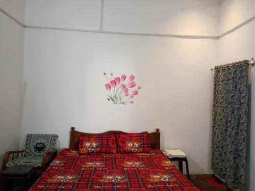 克久拉霍Holiday Home Stay的一间卧室配有一张带红色毯子的床