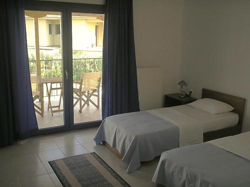 法纳里恩Hotel Alexandros的酒店客房设有两张床和一个阳台。
