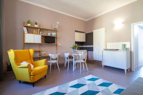 米兰Anna BnB的一间带黄色椅子的客厅和一间厨房