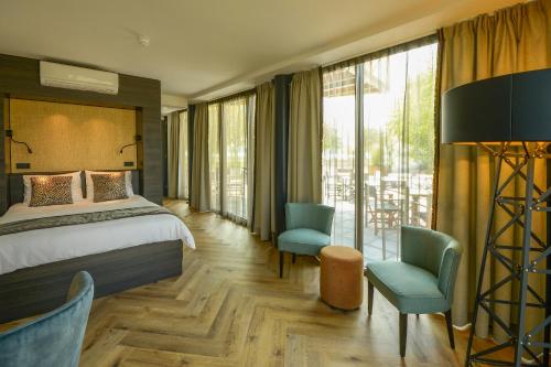 霍林赫姆Boutique Hotel Karel de Stoute的酒店客房带一张床、椅子和窗户