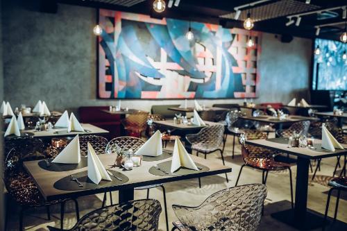 卢布尔雅那ibis Styles Ljubljana Centre的一间带桌椅的用餐室和一幅画