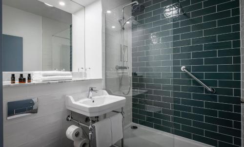 多纳贝特Shoreline Hotel的一间带水槽和玻璃淋浴的浴室