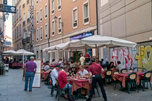 卡利亚里意大利酒店的一群坐在户外餐厅的桌子上的人