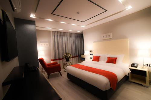 瓦迪穆萨Petra Boutique Hotel的酒店客房,配有一张床和一张红色椅子