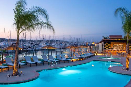 圣地亚哥科纳凯贵族山庄Spa度假酒店的一个带椅子的游泳池,晚上有码头