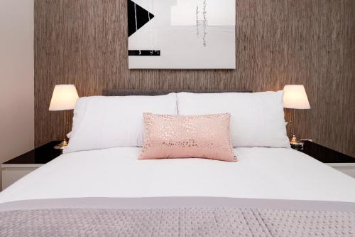 因弗内斯No. 6 Apartment的卧室配有白色床和粉红色枕头