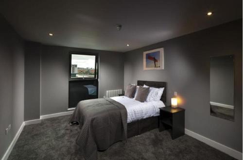 泰恩河畔纽卡斯尔Luxury Apartments Newcastle的一间卧室设有一张大床和一个窗户。
