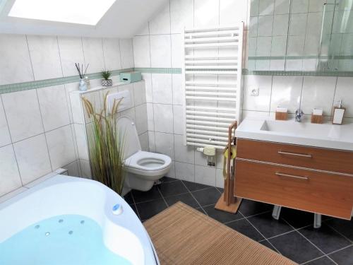 阿特湖畔施泰因巴赫FeWo Atterseeperle - 80m2 mit See- und Gebirgsblick的带浴缸、卫生间和盥洗盆的浴室