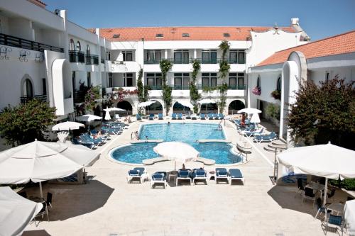 埃斯波森迪素雅唯马尔酒店的一座带椅子和遮阳伞的游泳池位于一座建筑旁边