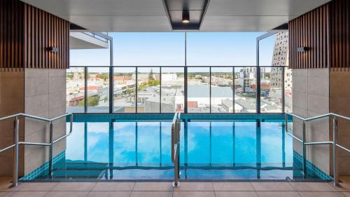 阿德莱德Avani Adelaide Residences的一座带大窗户的建筑中的游泳池