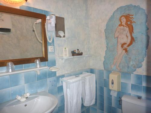 卡庞特拉菲阿科尔酒店的蓝色瓷砖浴室设有水槽和镜子