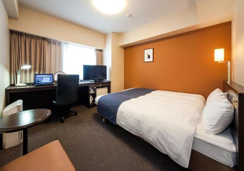 水户Daiwa Roynet Hotel 水戶的酒店客房配有一张床和一张带电脑的书桌