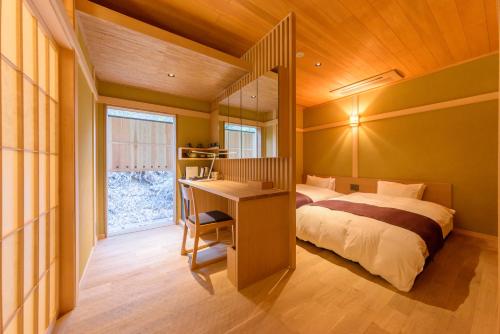 京都花筏日式旅馆的一间卧室配有一张床、一张书桌和一个窗户。