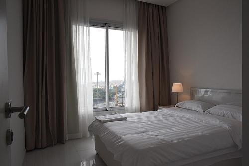 科威特Code housing - Al Bedaa- Family only的一间卧室设有一张床和一个大窗户