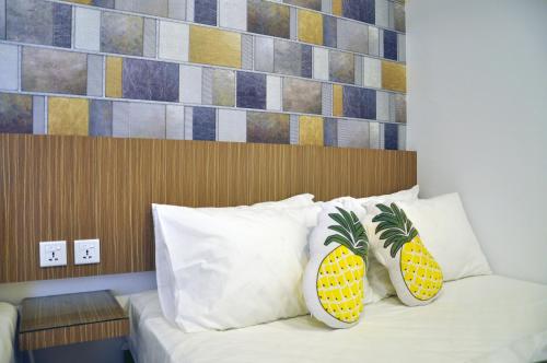 关丹Tas 96 Inn的一间卧室配有一张带 ⁇ 萝枕头的床。