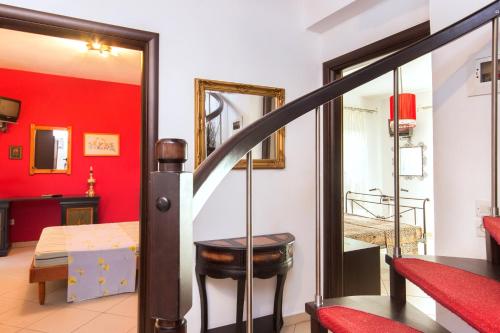 斯卡拉拉乔伊Villa Efi的一间设有红色墙壁的客房和一个带卧室的楼梯
