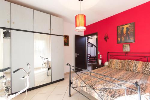 斯卡拉拉乔伊Villa Efi的卧室设有红色的墙壁和一张床