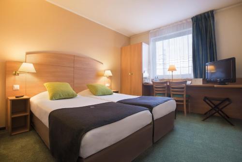 波兹南波兹南钟楼酒店的酒店客房设有两张床和电视。