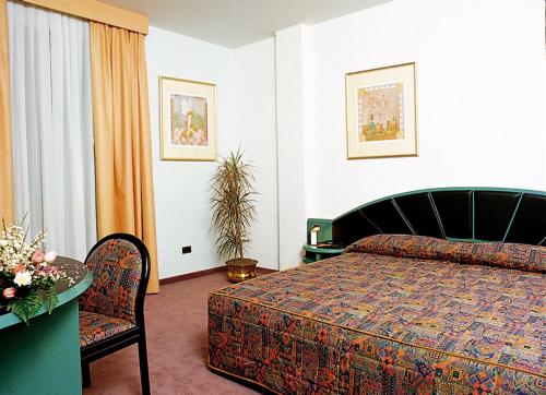 Vedelago安蒂卡波斯图米亚酒店的卧室配有1张床、1张桌子和1把椅子